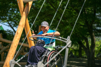 Rollstuhlfahrerschaukel mit Holzkonstruktion als Bodenmodellierung