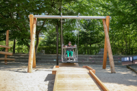 Rollstuhlfahrerschaukel mit Holzkonstruktion als Bodenmodellierung